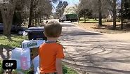 Little boy waits holding snacks for his friend - GIF