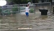 A man tries to drain a flood by using a bucket