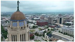 Nebraska state capitol building with Lincoln skyline. Aerial establishing shot.