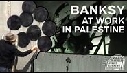 Banksy at work on the Palestine / Israel separation wall