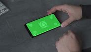 Free stock video - Holding smartphone with horizontal green screen chroma, reading, touching. mockup.
