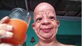 bald guy drinks orange juice