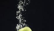 green apple falling into the water