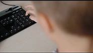 Boy Using Computer Keyboard Stock Video
