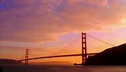 Silhouette of Golden Gate Bridge against moody sky at sunset (...