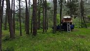 A Car Roof Top Tent for Camping on the Roof Rack of an Offroad Car in a Forest on a Misty Cloudy