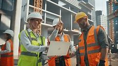 Portrait of a Site Manager Talking with General Operatives at a Residential Building Construction Area. Female and Male Employees Using a Laptop Computer to Oversee the Real Estate Project Plan