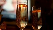 Close Up Of Golden Champagne With Bubbles In Flute Glasswares. low angle