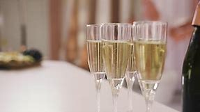 Free stock video - Side view of a champagne bottle and crystal glasses with champagne on a table at a bachelorette party