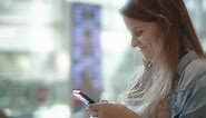 Woman Smiling While Texting on the Cellphone, Slow Motion