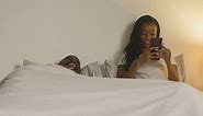 Free stock video - Couple at home at night lying in bed with woman looking at mobile phone 3