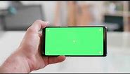 man hand holding the smartphone horizontally with green screen on watching ideos on the internet dur