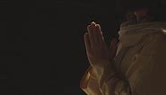 Free stock video - Close up of man wearing robes with long hair and beard representing figure of jesus christ putting hands together in prayer