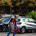 Woman Walking Between Cars at Parking Lot