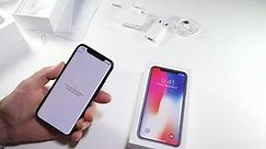 PARIS, FRANCE - NOV 3, 2017: Man POV unboxing of the latest Apple iPhone X 10 smartphone in white studio background waiting for the phone to activate