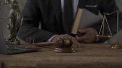 Sesión de audiencia judicial: Retrato de un juez varón sosteniendo un martillo en una tabla de honor de madera leyendo el veredicto. El Presidente de la Corte Suprema anunció el veredicto.