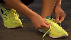 Running shoes. Barefoot running shoes closeup. Female athlete tying laces for jogging on road in minimalistic barefoot running shoes. Runner getting ready for training. Sport lifestyle.