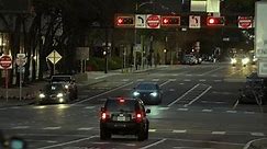 American wide multilane street intersection with traffic lights and moving cars at night. Transportation system in USA. Tampa, USA - March 15, 2023.