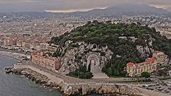 Nice France Aerial v7 drone flyover castle hill overlooking at war memorial rauba capeu and dense cityscape in quartier du port neighborhood with mountainous background - July 2021