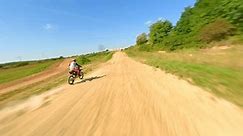 FPV of high-speed motocross bike on track. Concepts of extreme sports, racing, and adrenaline.