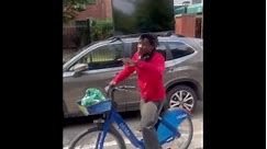 New York man balances TV on his head while riding bicycle — see the video!