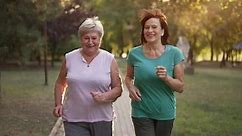 Two Cheerful Elderly Ladies Running at the Park