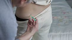 Nurse makes injection syringe antibiotic patients the shot in the buttocks.