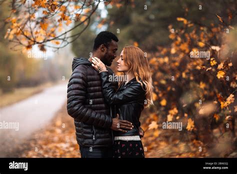 Happy Interracial Couple Walking In Autumn Park Black Man And White