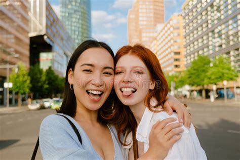 Two Young Beautiful Smiling Happy Girls Touching With Their Cheeks