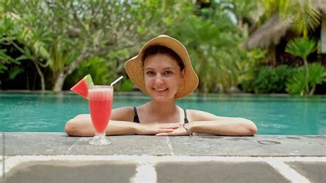 Smiling Woman Drinking Juice In Swimming Pool By Nikita Sursin