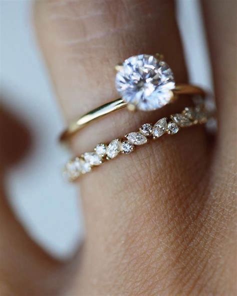 A Womans Hand With Two Gold Rings And A Diamond Ring On Her Finger