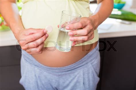 pregnant woman taking pill stock image colourbox