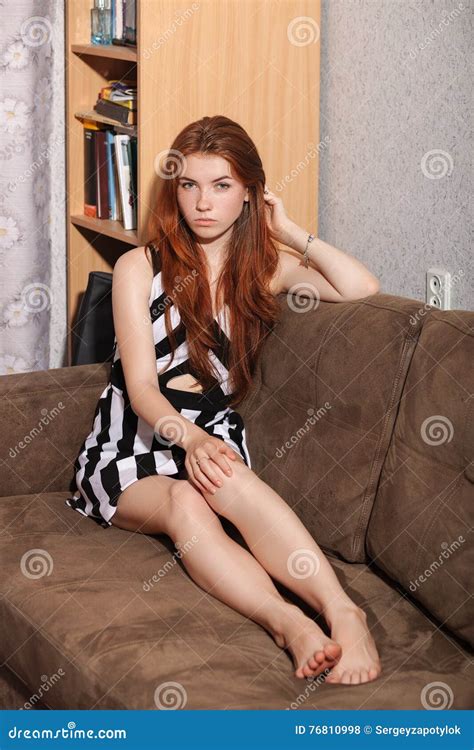 Candid Portrait Of Thoughtful Young Beautiful Redhead Woman Sitting On