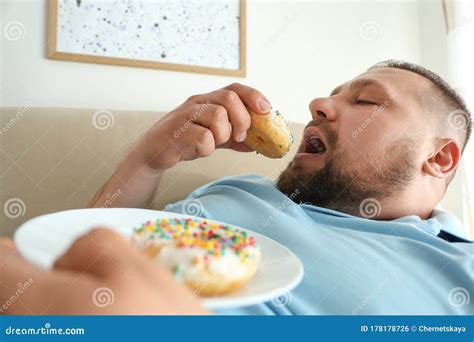 lazy overweight man eating donuts  home stock photo image  adult
