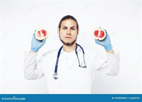 jonge mooie dokter met stethoscoop die fruit groenten en pillen vasthoudt spuit gezond
