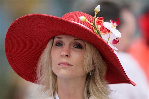 woman     grandstands wearing  hat prior