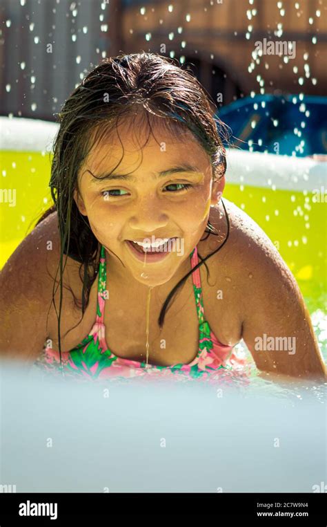 girl is smiling and playing in swimming pool a backyard pool party at
