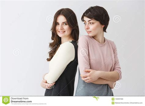 funny portrait of happy lesbian couple posing together in matching
