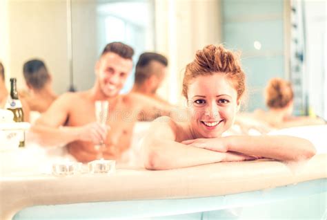 couple relaxing in bath drinking champagne together stock