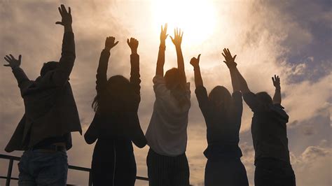 silhouette of people rejoicing and lifting up his hands a group of