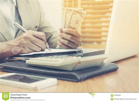 de bedrijfsvrouw met calculator tellend geld en het maken neemt nota van  stock foto image