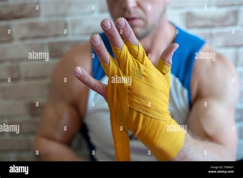 boxer bandages his hands before the fight with yellow bandages stock