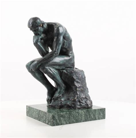 a bronze sculpture of the thinker after rodin