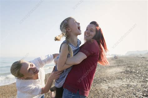 Lesbian Couple And Daughter Laughing On Beach Stock Image F023 0074
