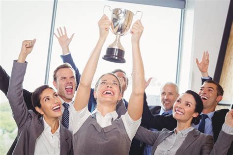 winning business team   executive holding trophy stock photo