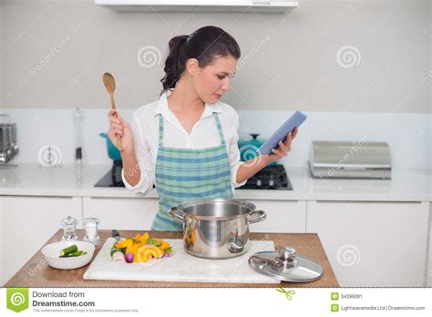 Focused Gorgeous Woman Wearing Apron Using Tablet While
