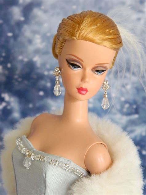 a barbie doll with blonde hair wearing a white dress and fur stole on