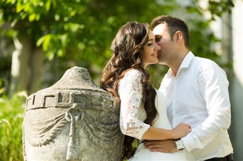 Stylish Gorgeous Happy Brunette Bride And Elegant Groom Kissing Stock