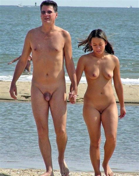 nude friends play around at a public beach pichunter