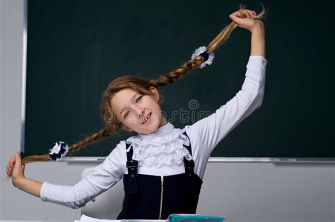 Schoolgirl Holding Her Braids Back To School Education Concept Stock